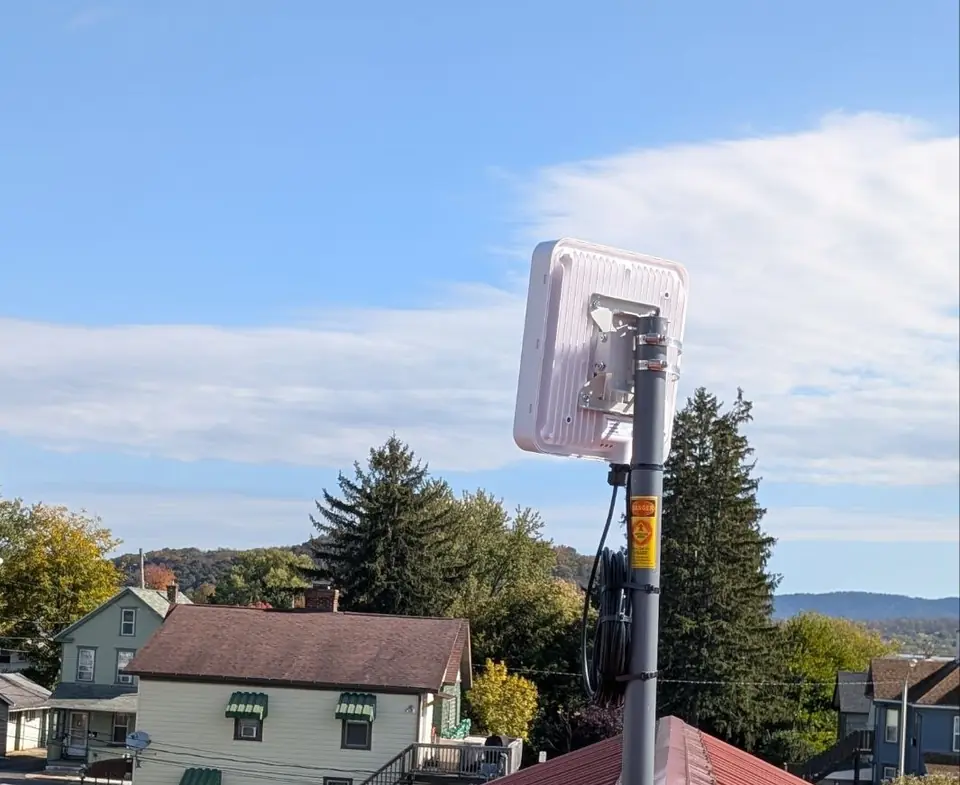 A Crowsnest radio on a mast above a red metal roof overlooking a small-town street.