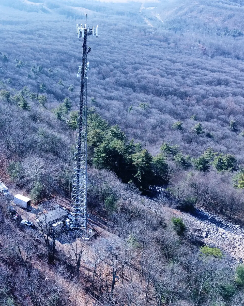 A Crowsnest tower site on a wooded ridge beside a winding road, seen from above in winter.